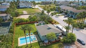 Zona residencial con piscina, una casa con garaje y vista al océano.