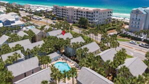 Un resort con piscina, vista a la playa y varias construcciones.