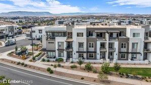 A modern apartment complex with multiple units, a visible road, and a distant mountain range.