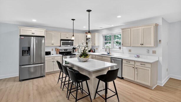 A modern kitchen with a central island, stainless steel appliances, and light-colored cabinetry. - Gray Woodland Escape Golf, Pool & Cinema 5 Bedroom Home (Gray)