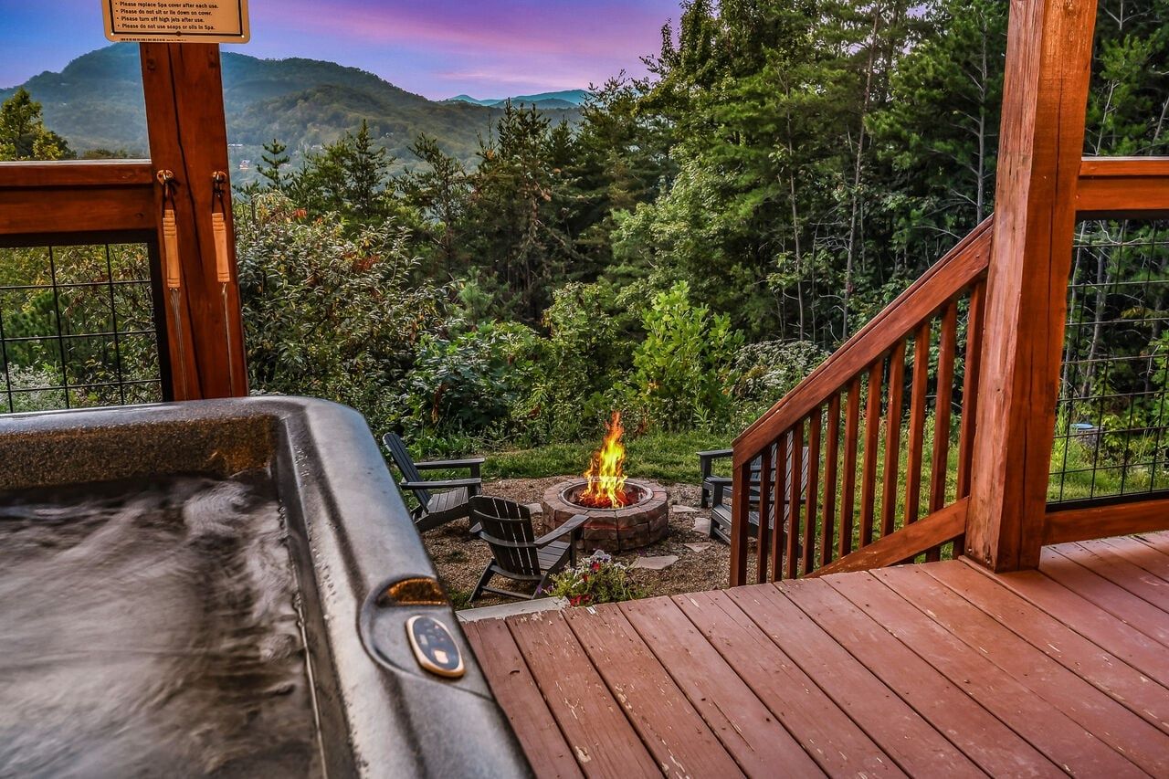 Un jacuzzi en una terraza de madera con un brasero en el centro, rodeado de un paisaje boscoso.