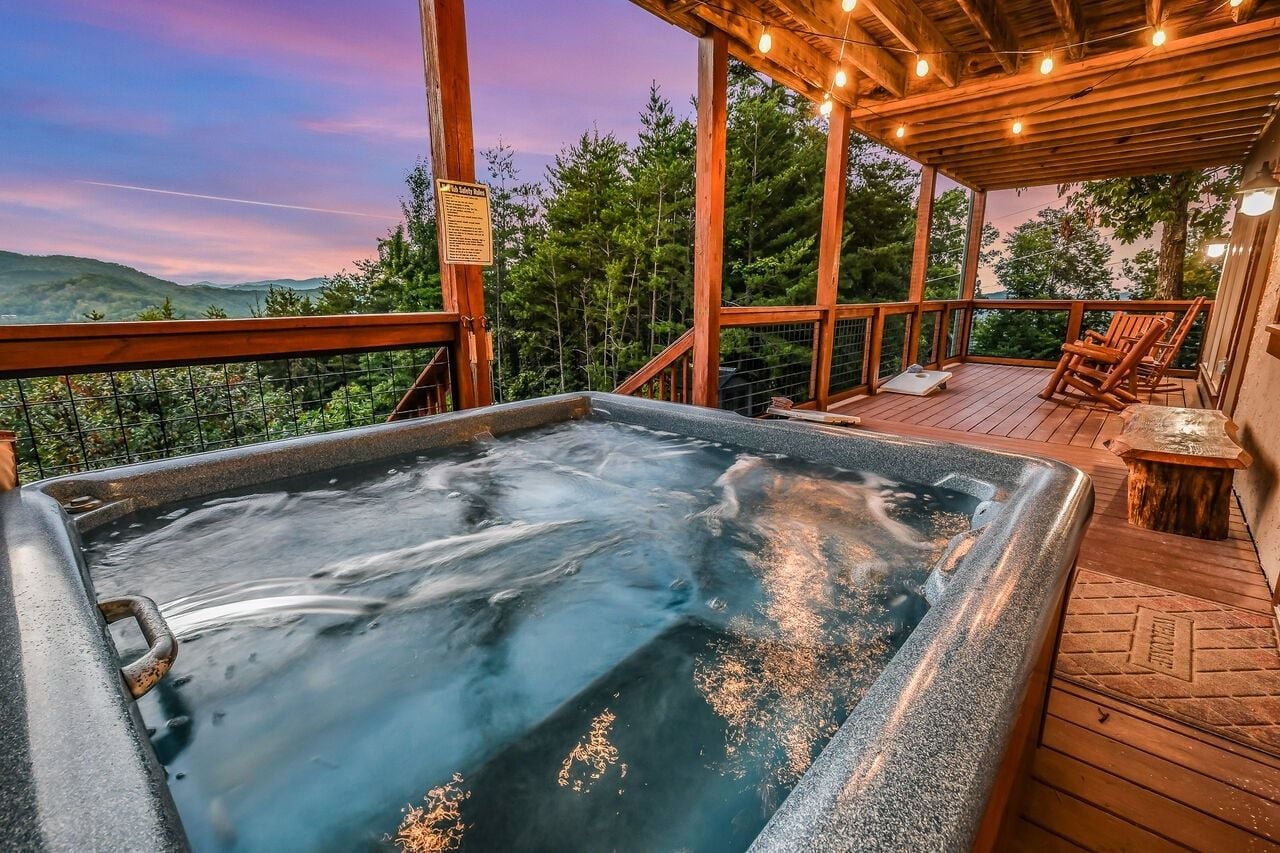 A hot tub on a wooden deck with a view of the surrounding landscape.