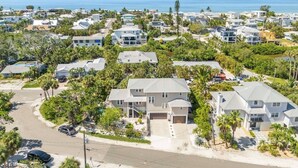 Zona residencial costera con casas, palmeras y una vista despejada del océano.