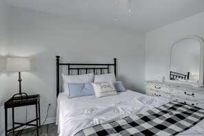 A neatly arranged bedroom with a bed, bedside table, dresser, and a mirror. - Luxury Pool Dog Friendly Central To Naples And Marco Island By Sky Run Naples 3 Bedroom Home (Naples)