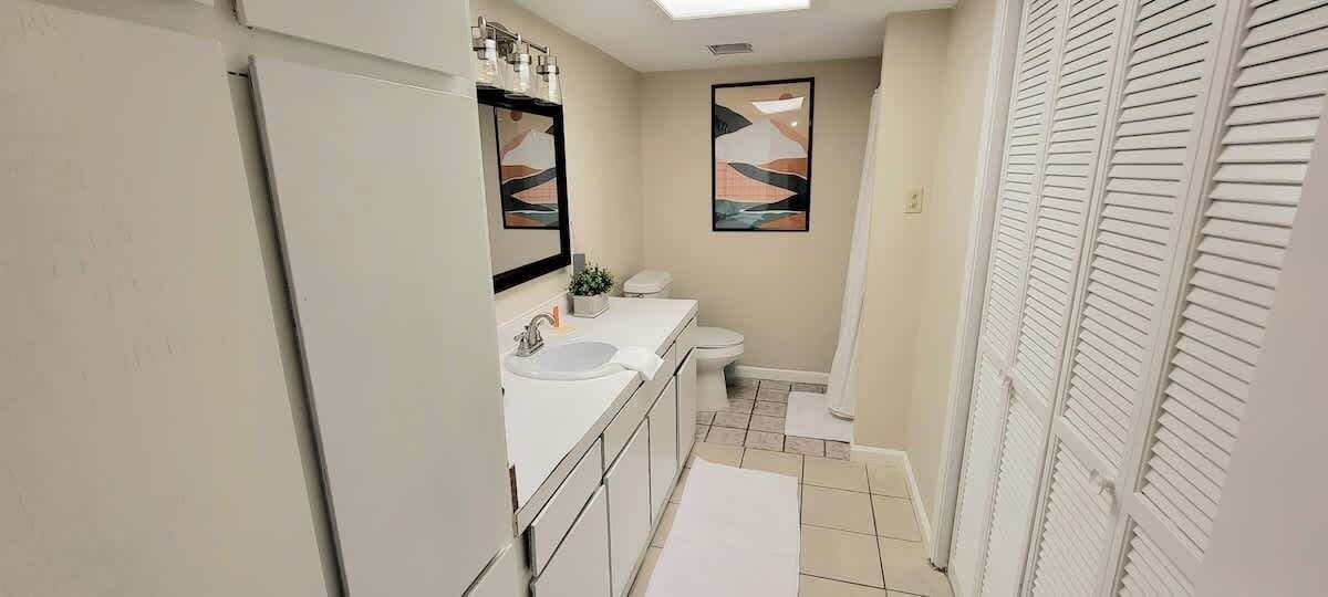 A bathroom with a sink, toilet, and shower area.