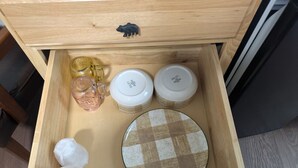 A wooden drawer with various items including jars, a plate, and a bear-shaped keychain. - South of the Border VT Room 1 (Canaan)