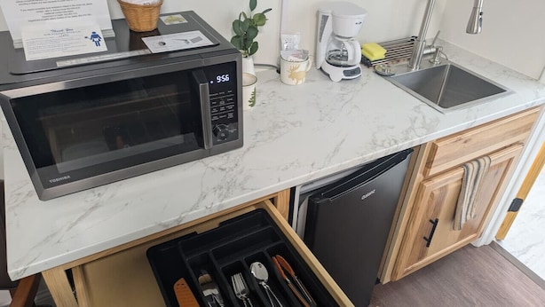 A compact kitchen with a microwave, coffee maker, and dishwasher. - South of the Border VT Room 1 (Canaan)