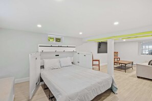 Une chambre à coucher avec un lit, une chaise, une table et un canapé.