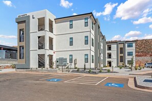 A multi-story hotel with a modern design, marked with "226 NORTH" on the facade. It features a parking lot with designated handicapped parking spaces.