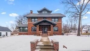 A two-story brick house with a front porch and a garage.