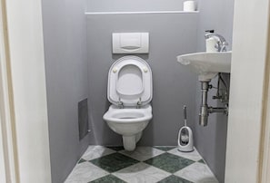 A bathroom with a toilet, a sink, and a bidet.