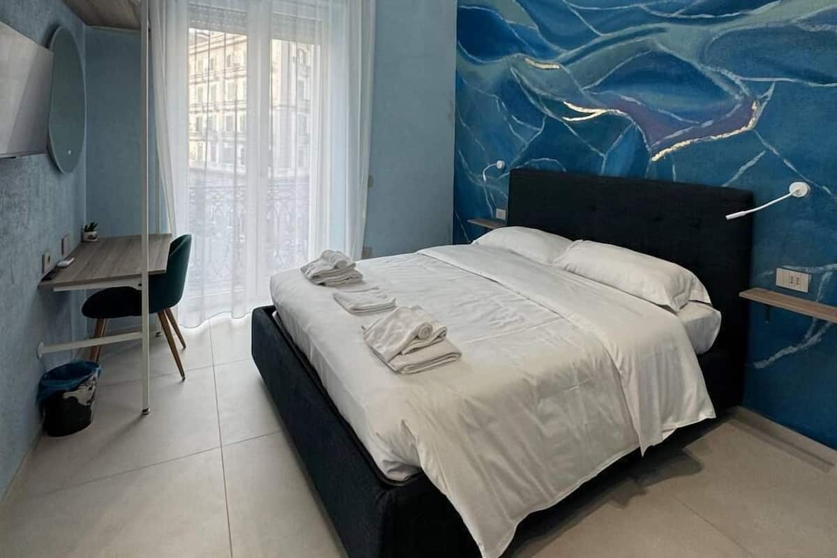 Un dormitorio moderno con cama, escritorio y silla.
