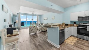 Una cocina moderna con una isla central, armarios blancos y vistas al exterior.