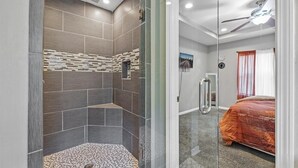 A modern bathroom with a shower, a glass-enclosed shower area, and a visible bedroom with a bed and window. - Sleeps 8 - Central Golf Getaway (Atlanta)