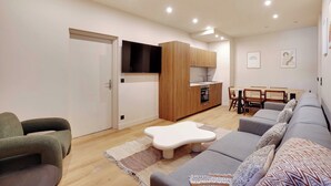 Un salon moderne comprenant un canapé, une table basse et un coin repas avec des chaises et une table.