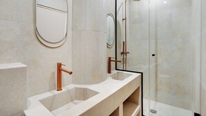Une salle de bain moderne avec deux lavabos, un grand miroir et une douche à parois de verre.