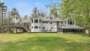 A large, multi-story house with a covered patio and a deck.