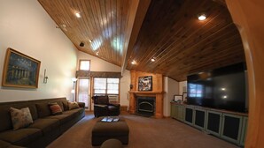 A cozy living room with a fireplace, a large TV, and a leather sofa. - Swiss-charmed Mountain Retreat NEW Listing (Midway)