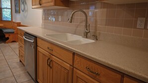 A kitchen with wooden cabinets, a double sink, and a dishwasher. - Swiss-charmed Mountain Retreat NEW Listing (Midway)