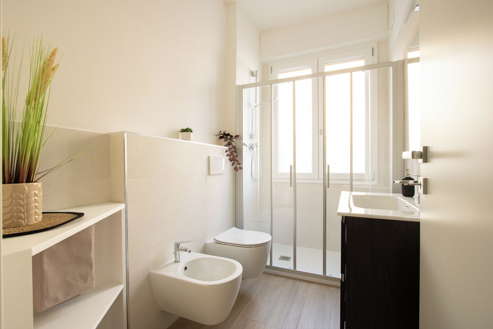 Ein modernes Badezimmer mit Dusche, Bidet und Waschbecken.