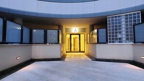 A modern building entrance with a central doorway marked by a large illuminated 'A'. - Annasole's flat by Domus&Dimore (Rome)