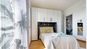 A bedroom with a bed, wardrobe, and a bathroom visible through an open door.