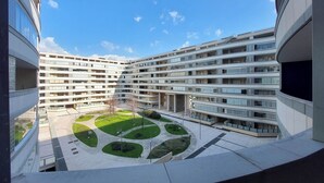 Un immeuble à plusieurs étages doté d’une cour intérieure agrémentée d  ’espaces verts et d’une zone circulaire centrale.