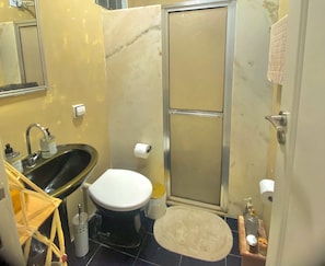 A bathroom with a sink, toilet, and shower.