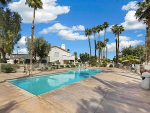 A swimming pool with lounge chairs and palm trees. - Luxury Palm Desert Condo: Pool & Mountain Views (Palm Desert)