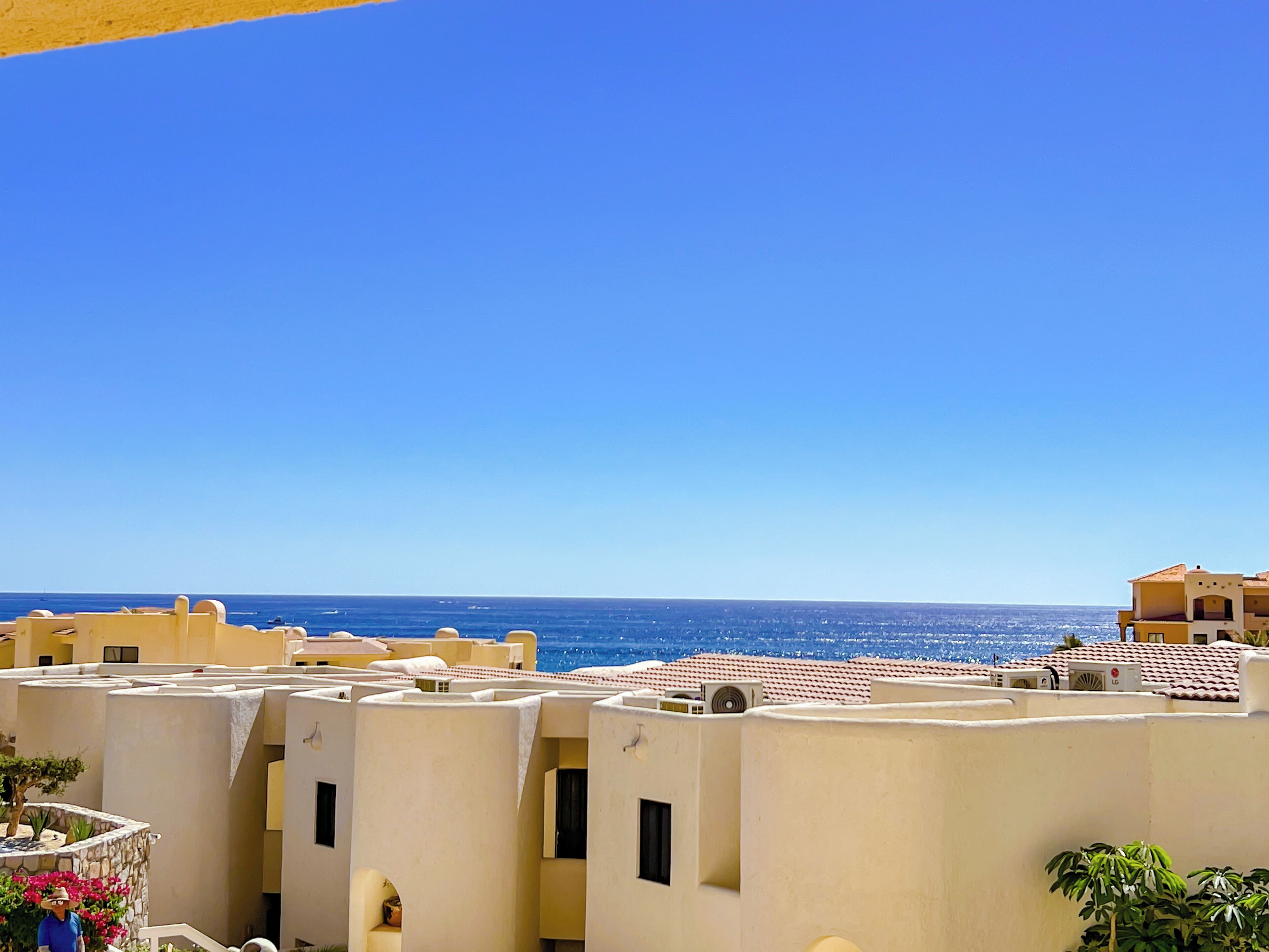 A coastal residential area with buildings featuring flat roofs and light-colored walls.