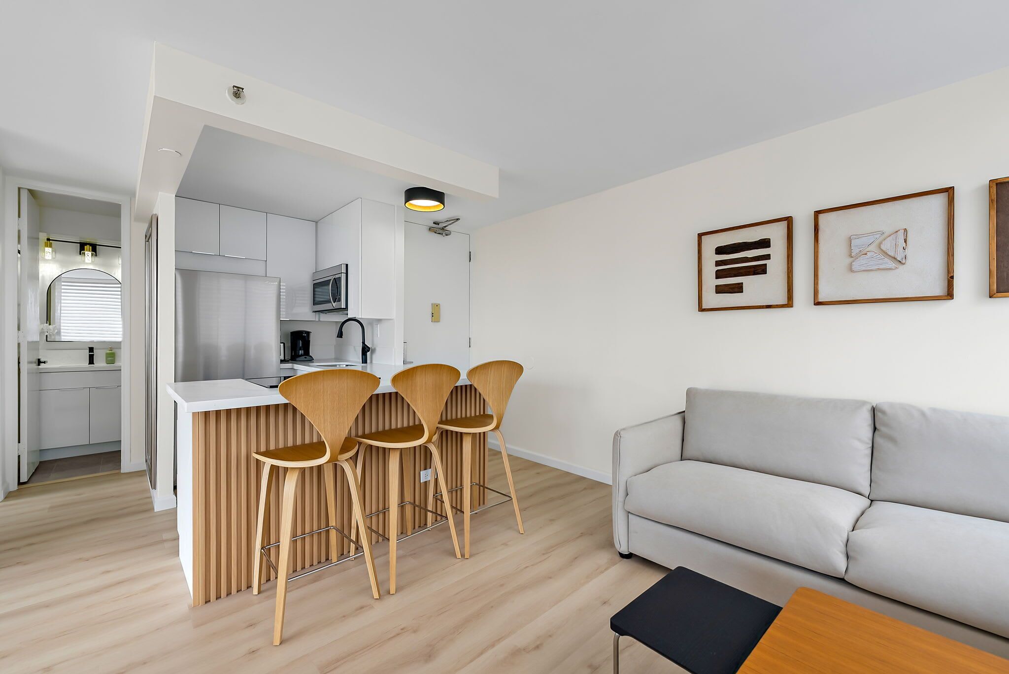 A modern apartment with a kitchen, dining area, and living room.