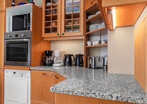 A compact kitchen with a microwave, oven, coffee maker, kettle, and toaster. - Comfy Room in Shared Villa w/ Free Parking (Wien)