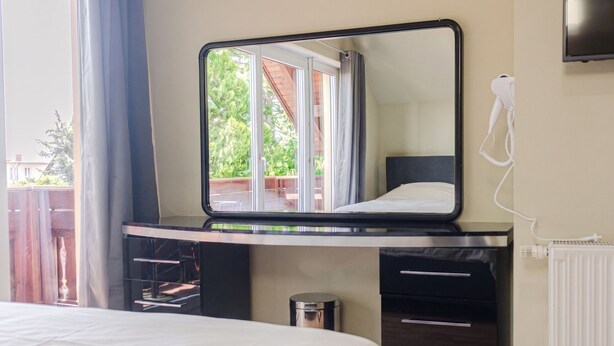 A bedroom with a bed, a dresser, a mirror, and a radiator. - Comfy Room in Shared Villa w/ Free Parking (Wien)