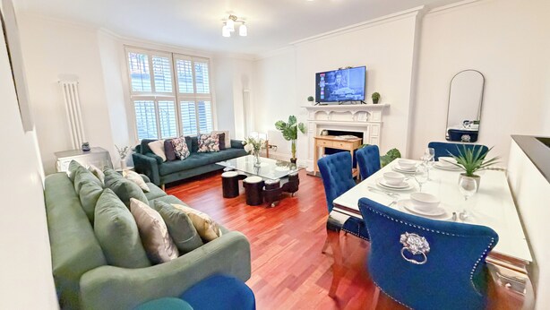 A modern living room with a sofa, coffee table, and dining area.