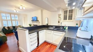 A modern kitchen with white cabinets, a black countertop, and a built-in oven.