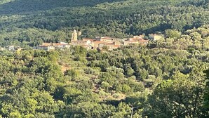 A hillside village with traditional buildings and a prominent church.