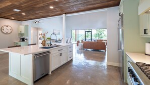 Una cocina amplia con una isla grande, electrodomésticos modernos y vistas al área de estar.