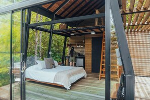 Een slaapkamer met een bed, een bureau en een trap.