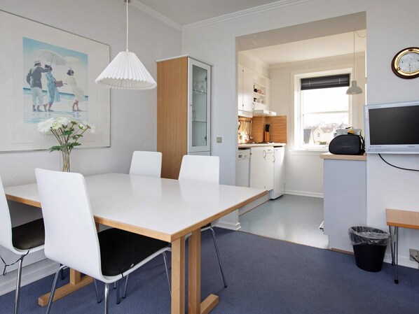 A modern kitchen with white cabinets, a wooden countertop, and a built-in oven.