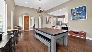 A spacious kitchen with modern appliances, a dining area with a large table, and a view of the outdoors. - Hill Country Retreat & Casita (Horseshoe Bay)