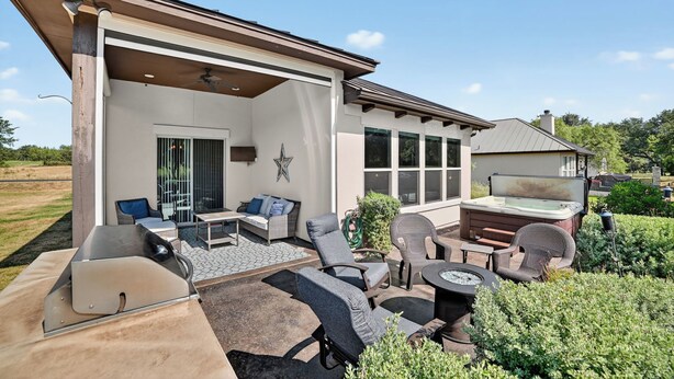 A covered outdoor patio with seating, a hot tub, and a grill area. - Hill Country Retreat & Casita (Horseshoe Bay)