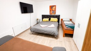 A bedroom with a bed, bedside tables, a TV, and a painting. - Charming Villa Stay | Garden & Parking Included (Wien)