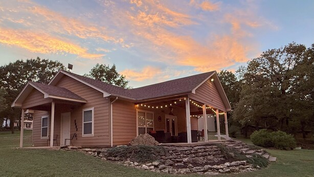A two-story house with a covered porch and string lights.