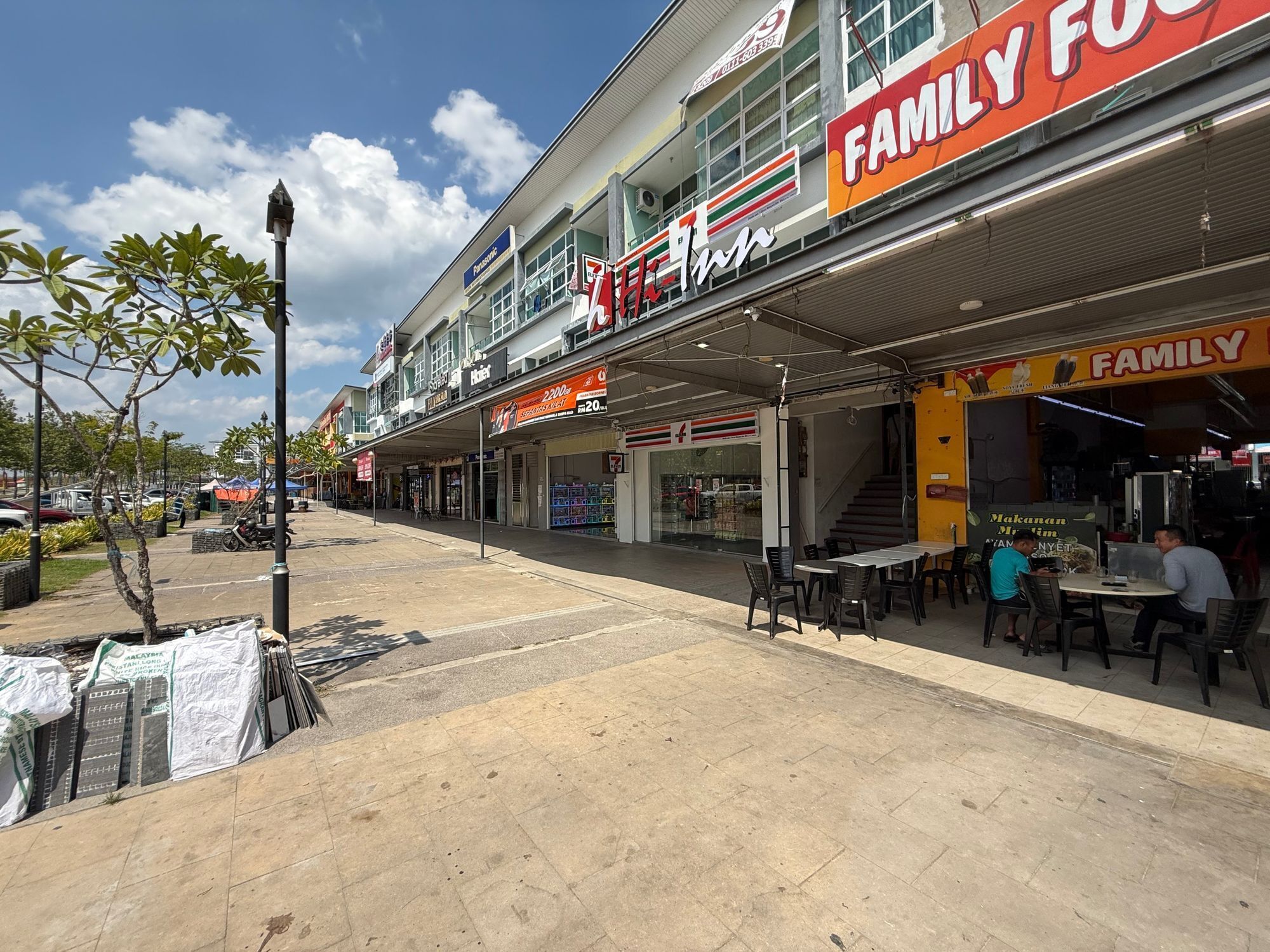 A commercial area with a 7-Eleven store, a Family Food restaurant, and a Panasonic store.