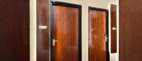 Un pasillo con dos puertas de madera, cada una con una placa numerada.