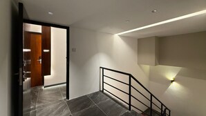 A modern interior with a staircase, a door leading to another room, and recessed lighting. - OYO 91193 Hi Inn Sibu Jaya (Sibu)