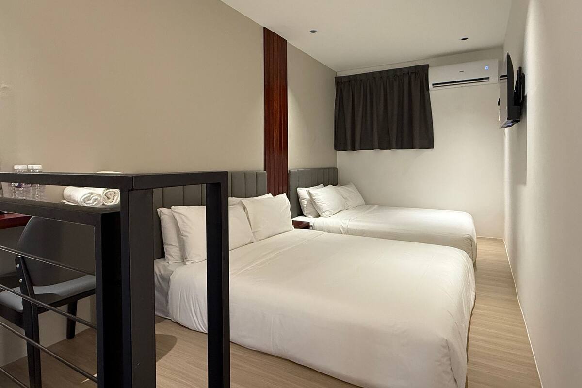 Una habitación de hotel con dos camas, un escritorio y una silla.