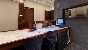 A modern office space with a desk, chairs, a computer, and a calendar. - OYO 91193 Hi Inn Sibu Jaya (Sibu)