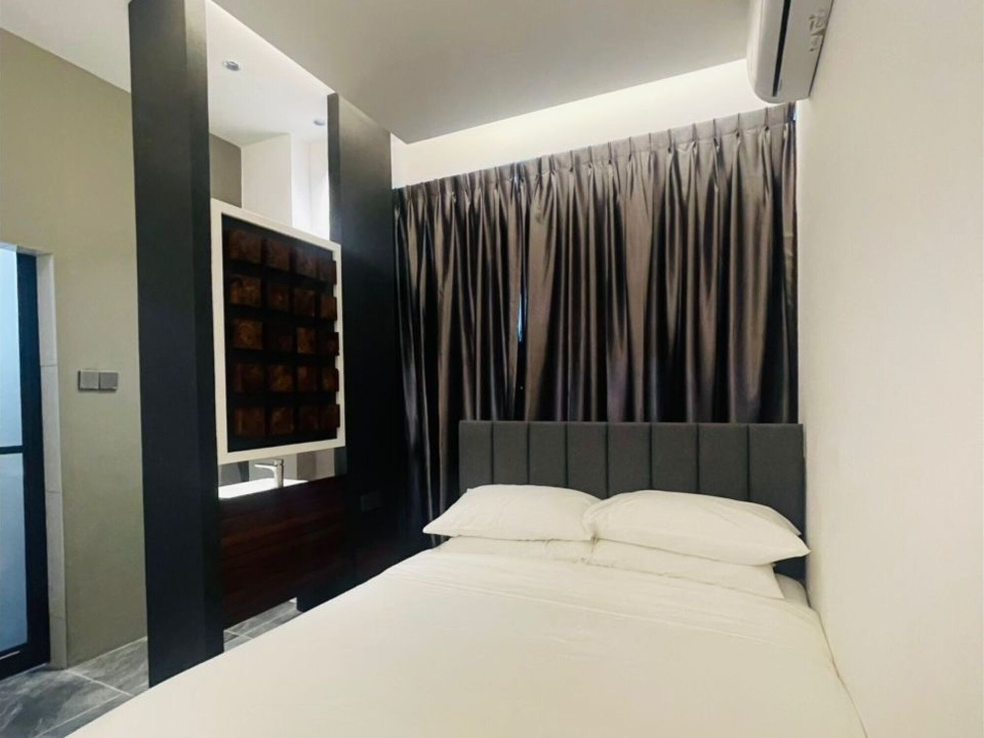 Un dormitorio moderno con una cama grande, un armario empotrado y una pequeña zona de estar.