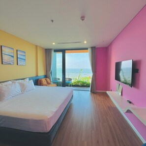 Habitación de hotel con cama, televisión, balcón y vistas, además de una ventana.